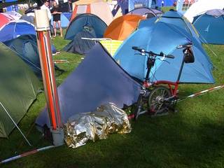 Zelt, Fahrrad und Rucksack unter Rettungsdecke